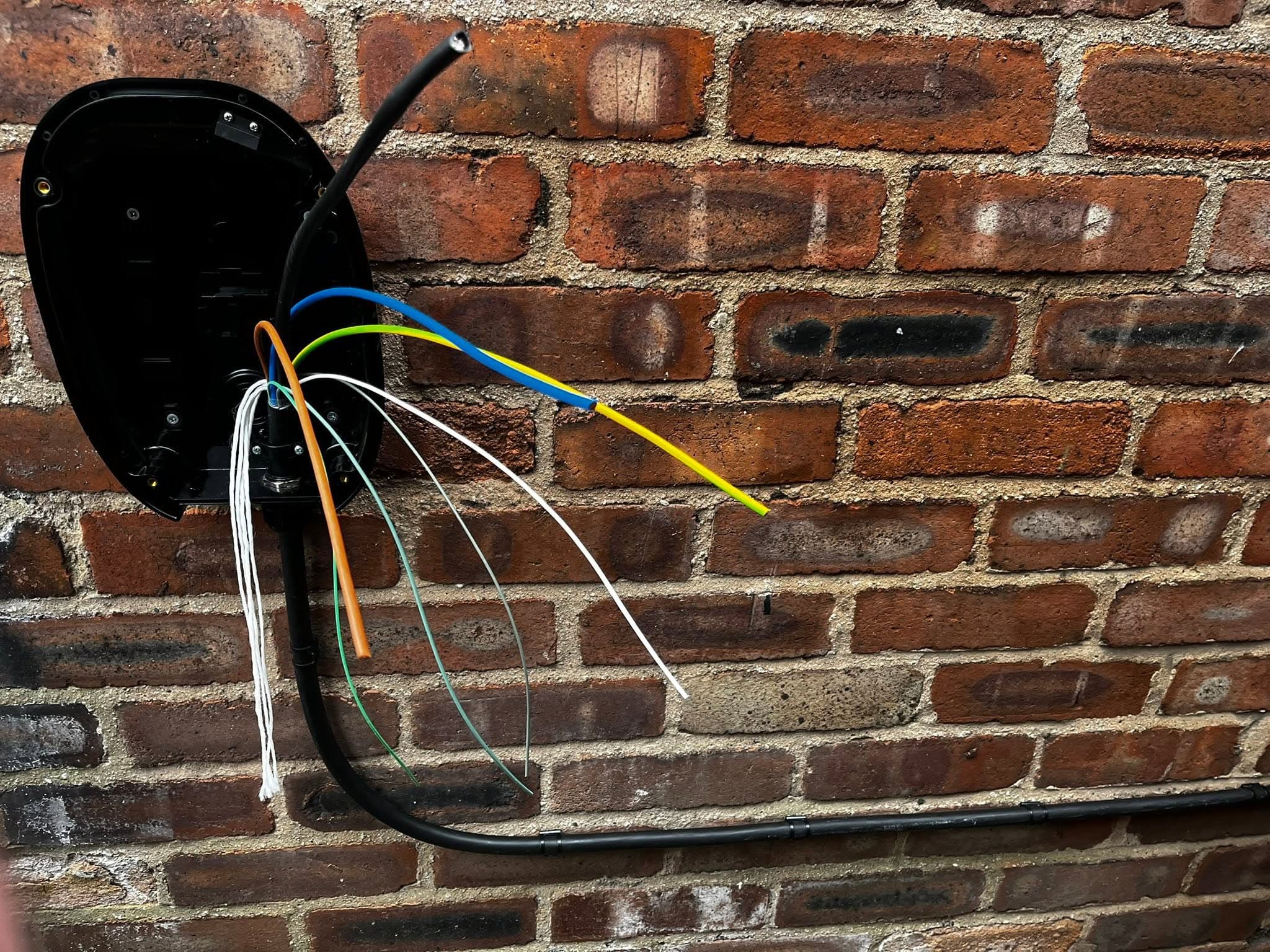 EV charger back plate during installation, supply and earth cables run in ready for connection