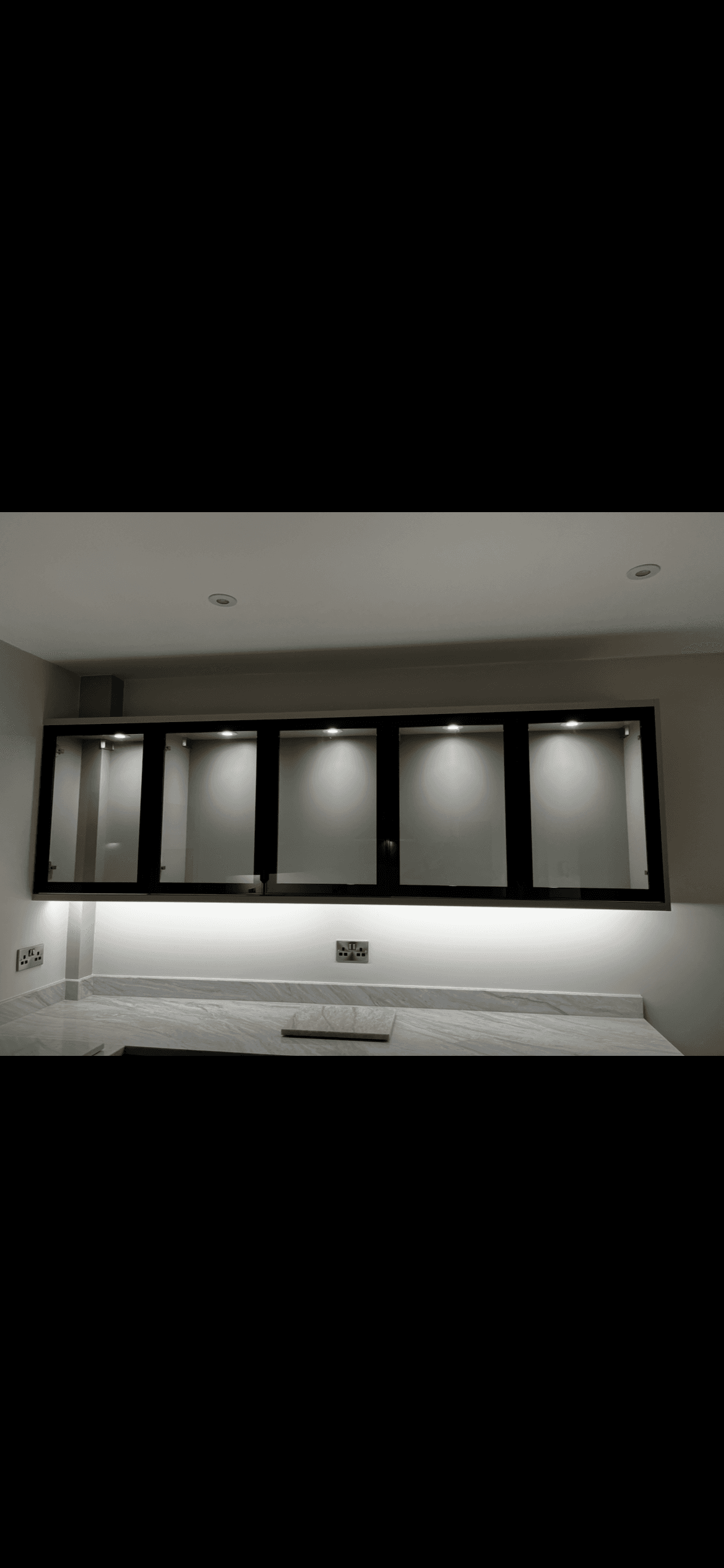 Kitchen with under-cabinet LED lighting and lit glass display units